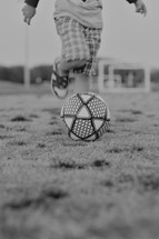 child running kicking a soccer ball