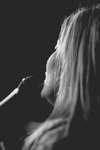 woman singing into a microphone