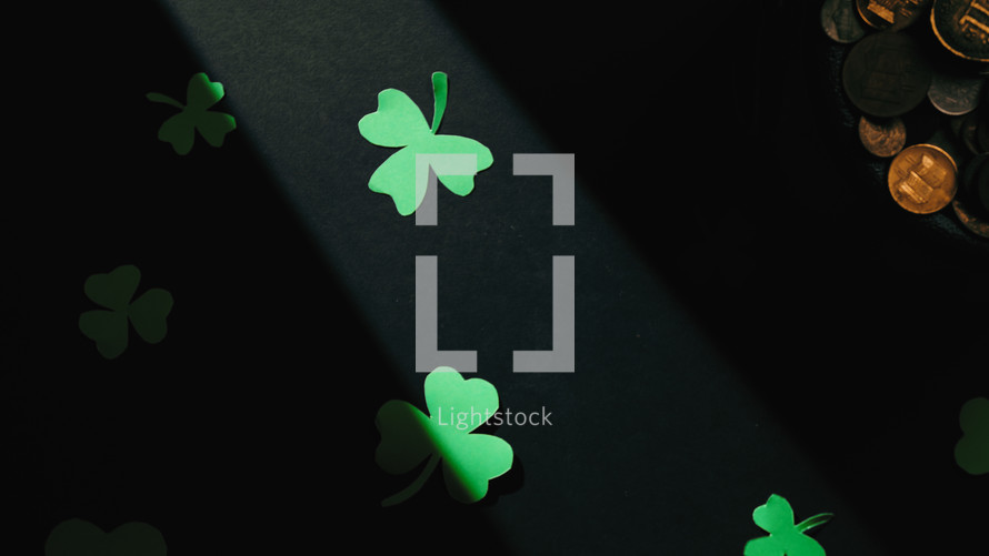 Background of clover decorations and golden coins for Clover St. Patrick's Day