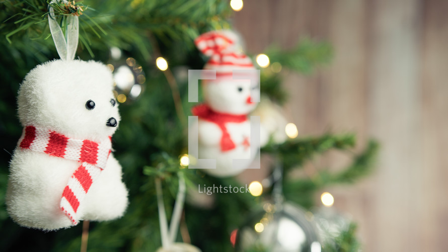 Small polar bear and snowman decorating a Christmas tree