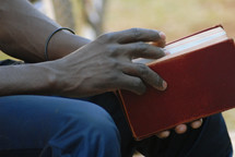 man resting holding a Bible 