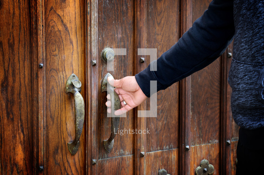 a man opening a wooden door 
