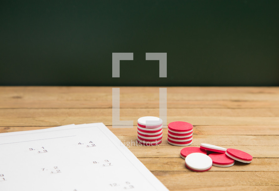 Simple Math Worksheet on a Wooden Table with counting markers 
