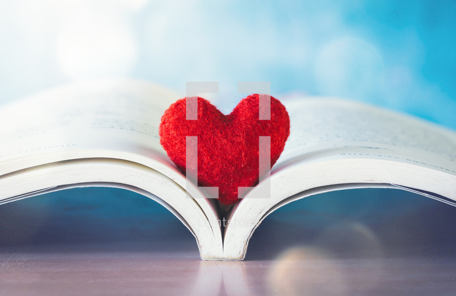 felt heart on the pages of an open Bible 