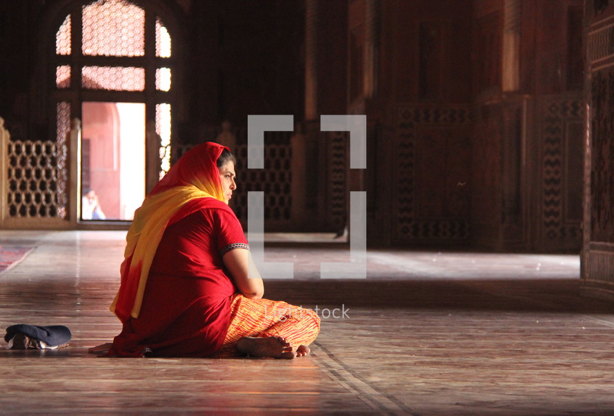 woman sitting in prayer inside a Mosque 