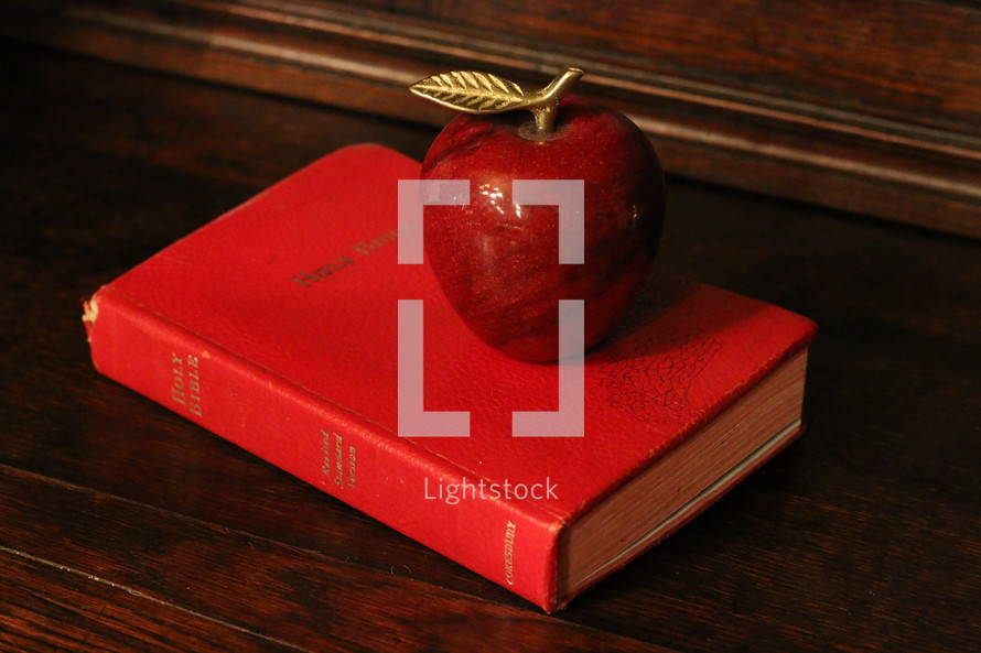 apple paper weight on a Bible 