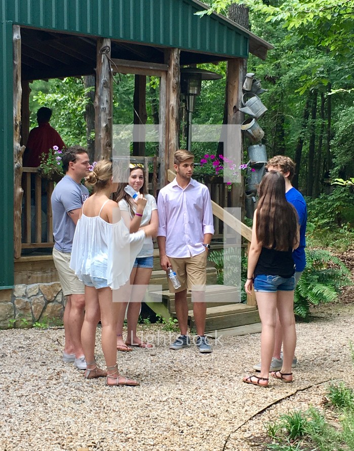 youth talking outdoors near a cabin at summer camp 