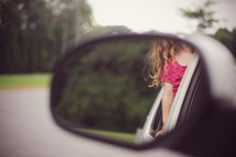 child's curls in a rearview mirror 
