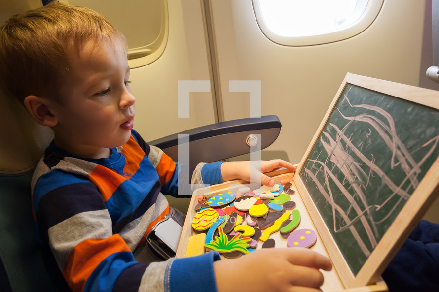 Boy in the plane drawing on board with chalk