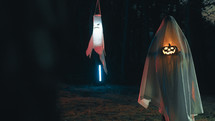 Ghost With Halloween Pumpkin In The Night Forest With Halloween Pumpkin