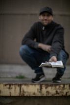 a man holding out a Bible 
