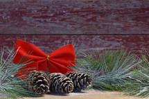 red bow, pine cones, and Christmas greenery 