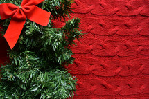 garland greenery and red knit background 