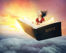 Child flying on a Bible through the clouds.
