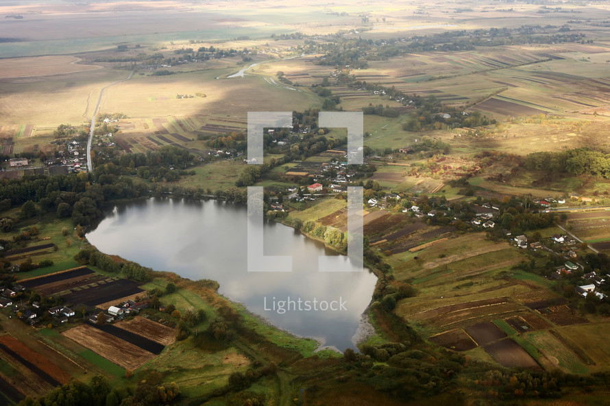 view of the village from the sky. photo with noise. Aerial view of farmland area landscape and lake from airplane. Landscape with lake. Environment protection. Drone flight
