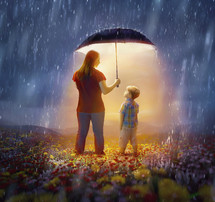 A mother protects her son from the rain with her umbrella.