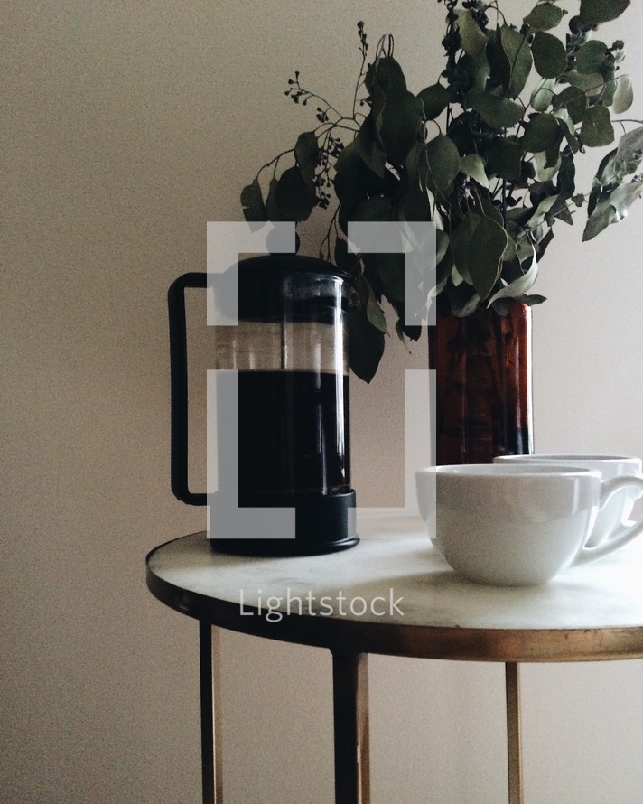 coffee pot and mugs on a side table 