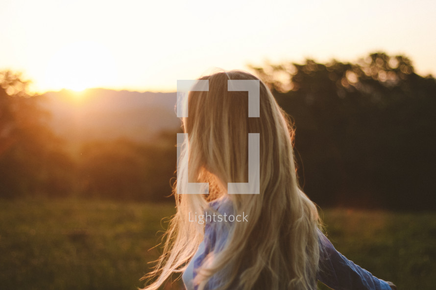 Women looking at the sunset on a filed