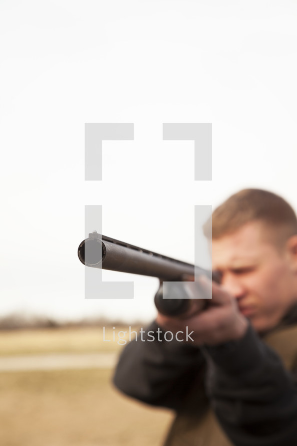 a man pointing a shotgun 