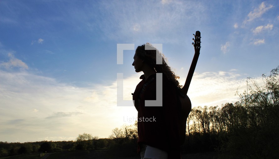a girl with a guitar on her back 