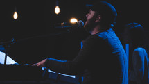 a man playing a digital piano on stage 