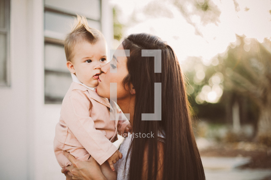 A young woman kisses a baby.