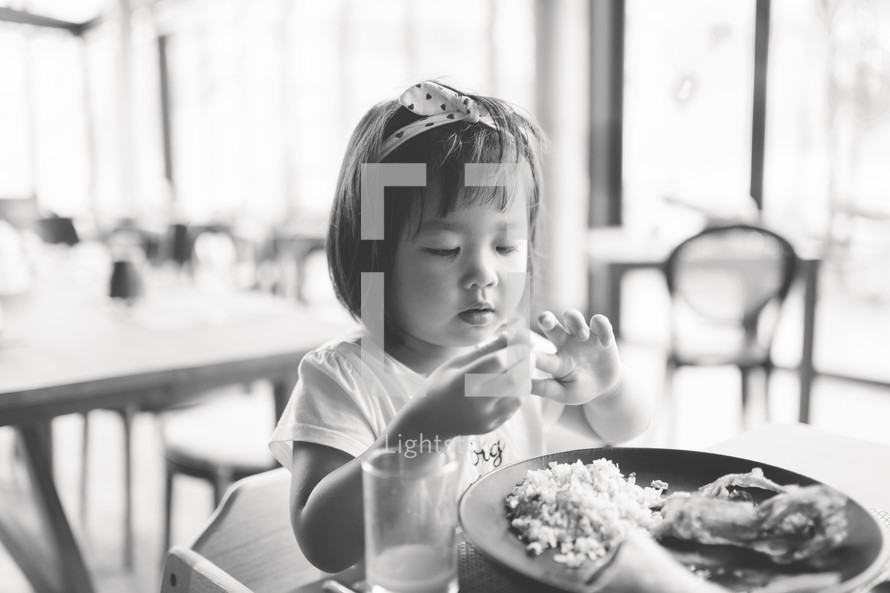 a toddler girl eating food 
