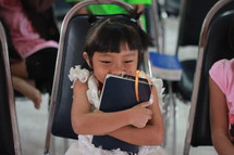 Little girl in Thailand with her beloved BIBLE