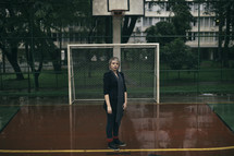 a woman standing on a wet basketball court 