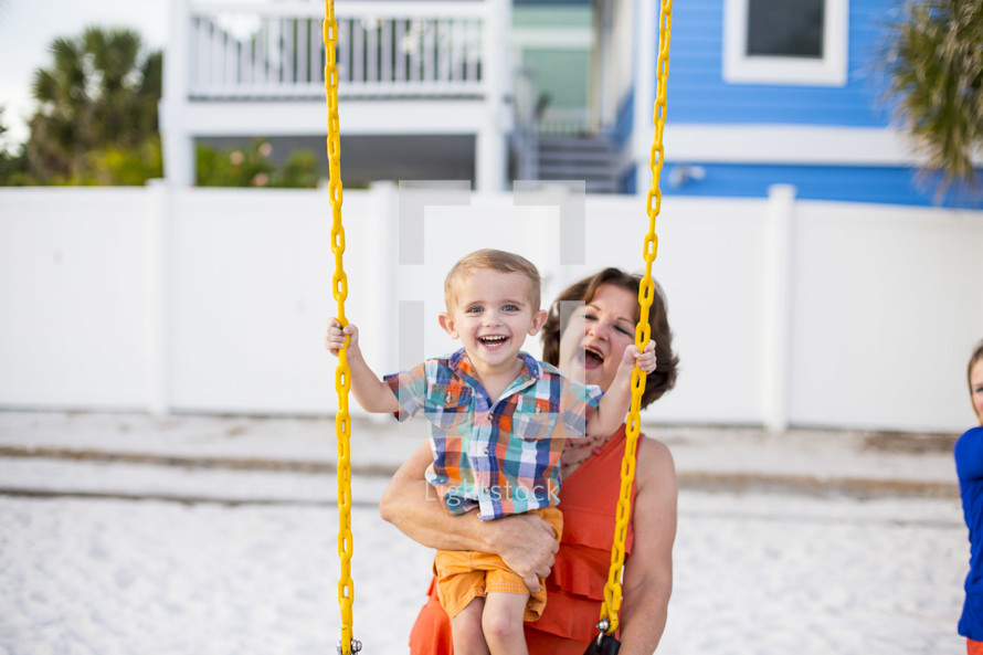 grandmother pushing her grandchild on a swing 