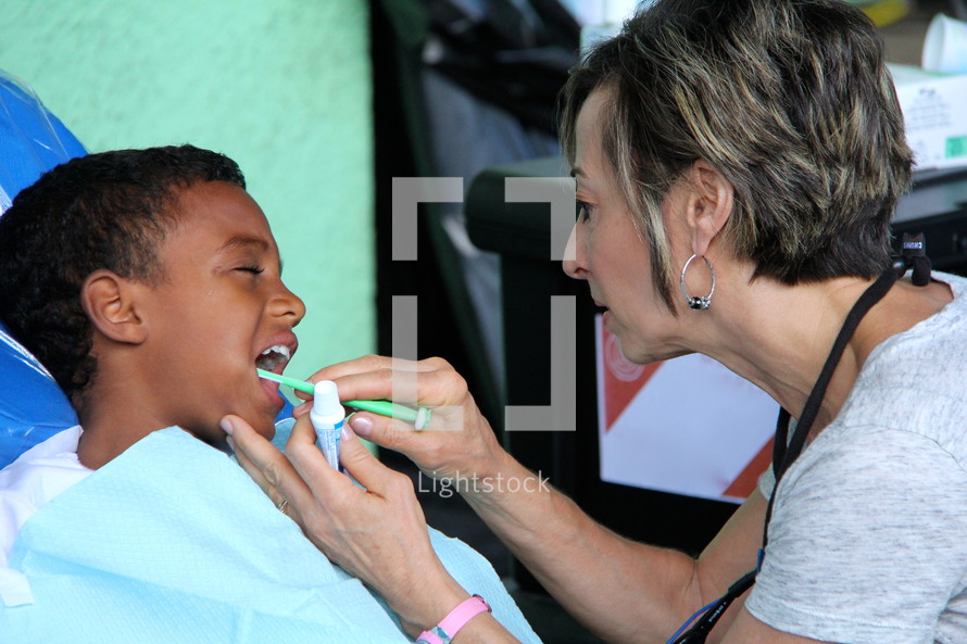 woman brushing a child's teeth