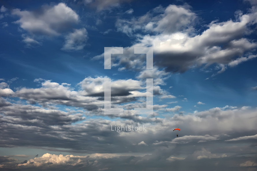 parachutist flying on the background of the beautiful sky. skydiver in the sky. a lone parachute among beautiful clouds. Active Hobbies.