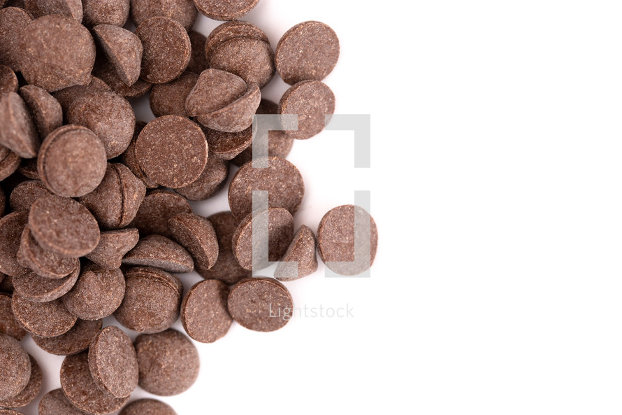 A Pile of Unsweetened Carob Chips on a White Background