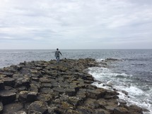 man walking on a rock jetty 