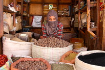Muslim woman with a shrouded face in a market  [For similar search Ethnic Face Smile]. 