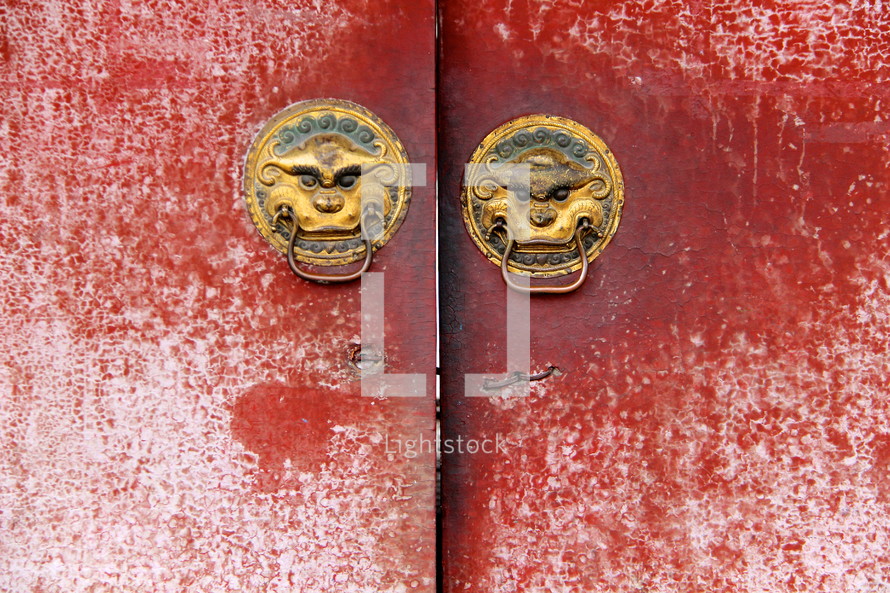 Chinese door handles on an ancient red door