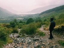 person in a raincoat hiking the hills of Scotland 