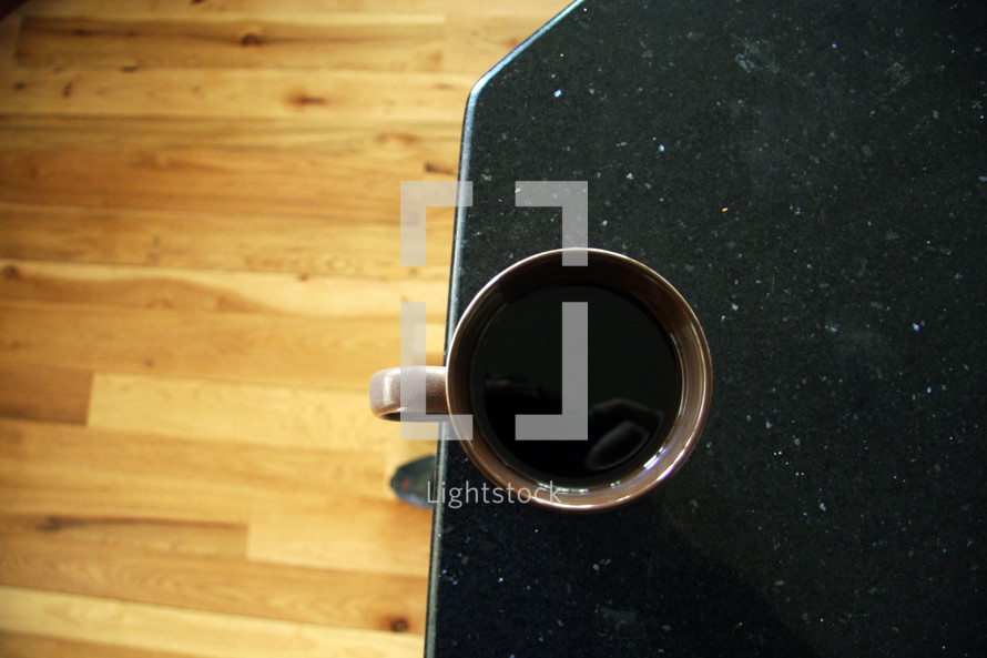 coffee mug at the edge of a table 