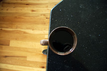 coffee mug at the edge of a table 