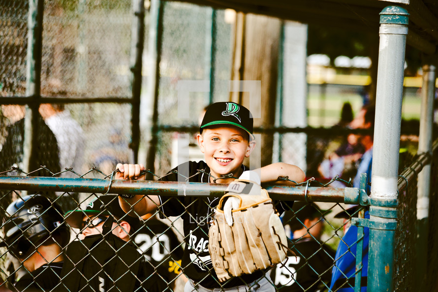 kids in a dugout at a baseball game 