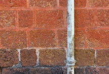 brick wall with rusted water pipe
