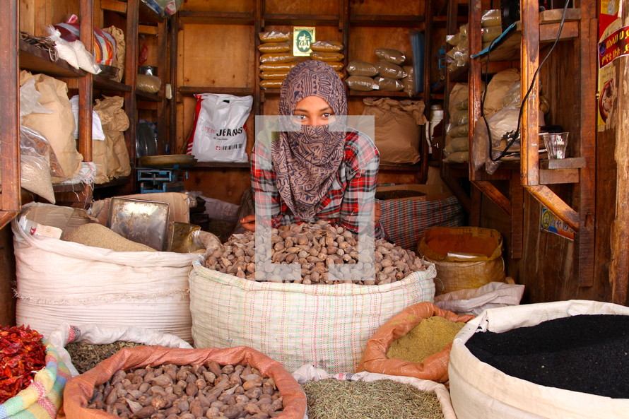 Muslim woman with a shrouded face in a market  [For similar search Ethnic Face Smile]. 