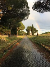 rainbow over a cobblestone road 