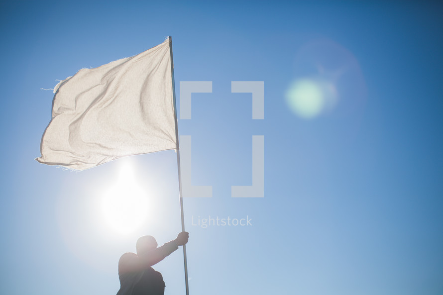 A man carrying a white flag of surrender
