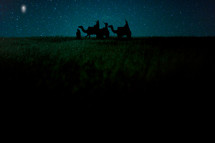 wisemen traveling on camels under the stars 