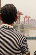 A man gazing at a dam.