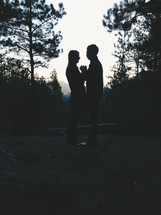 Silhouette of embraced couple outside at dusk.