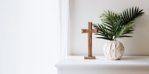 Palm Sunday. Wooden cross and palm leaf on a white shelf in the room