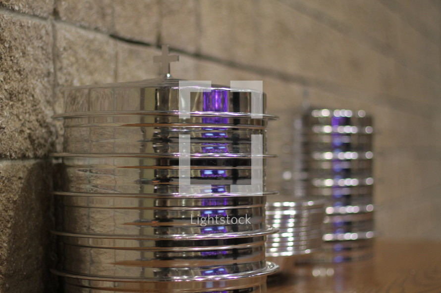 Stacks of silver communion trays.