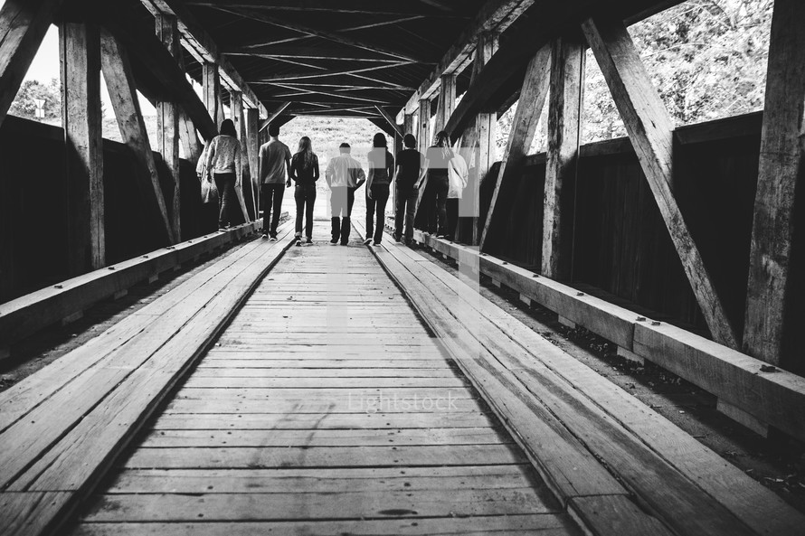 teens walking on a covered bridge 